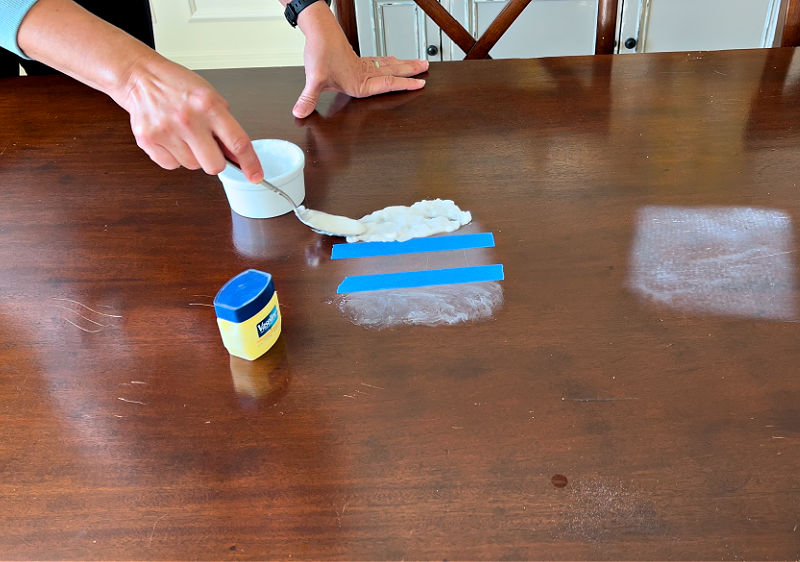 Using baking soda on a white heat stain on a wood table.