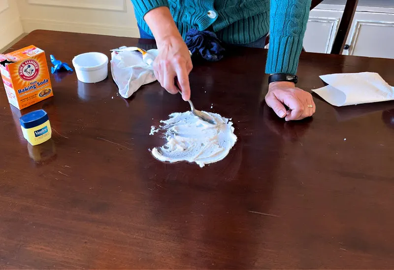 Using toothpaste and baking soda to remove a heat stain on wood tables.