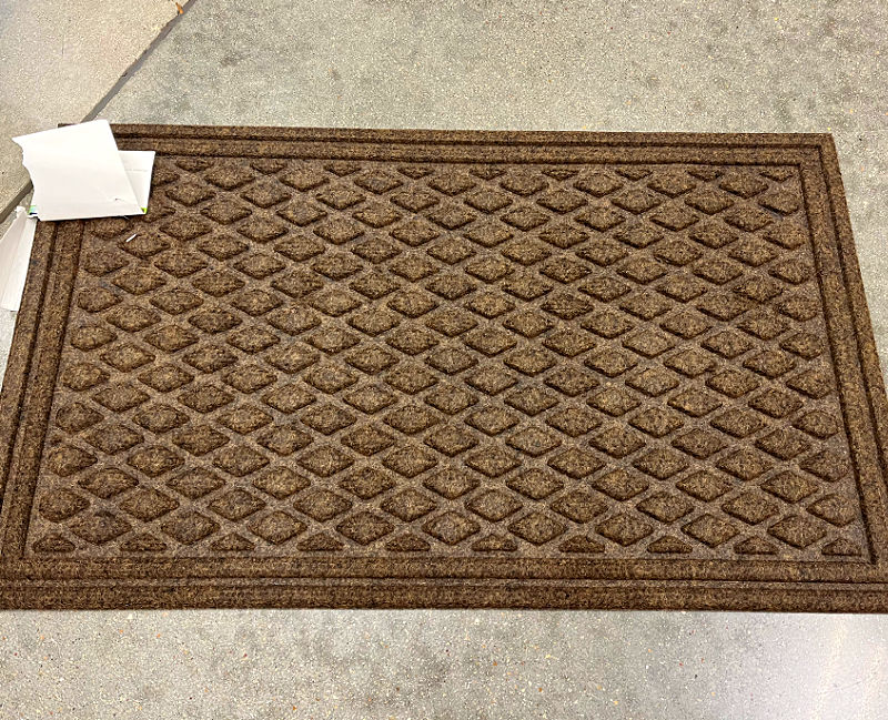 Textured synthetic fiber doormat with a rubber base.