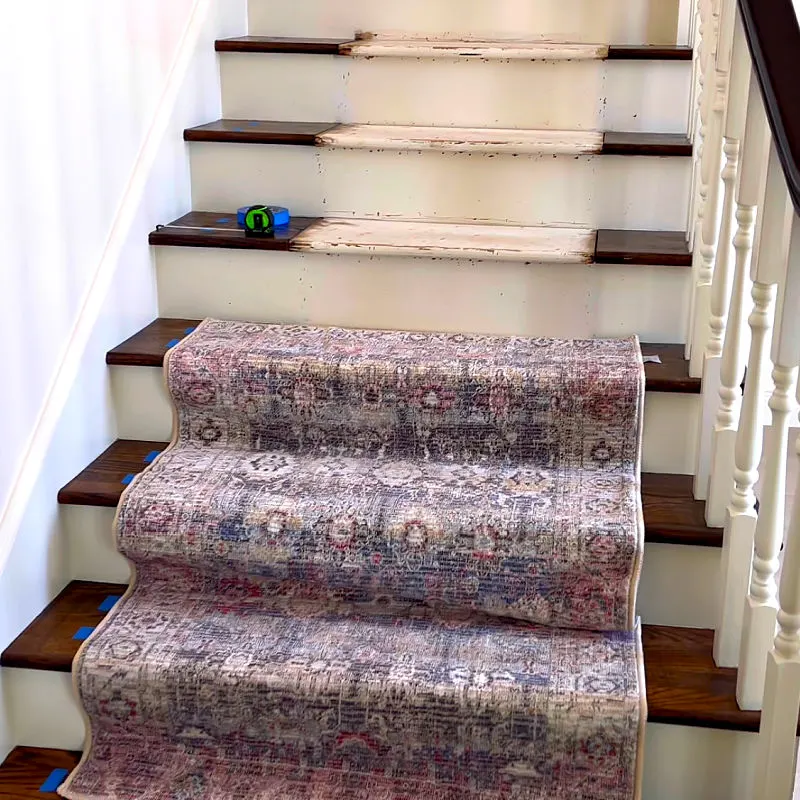 A 3x5 area rug on a wide set of stairs before installing the rug on stairs.