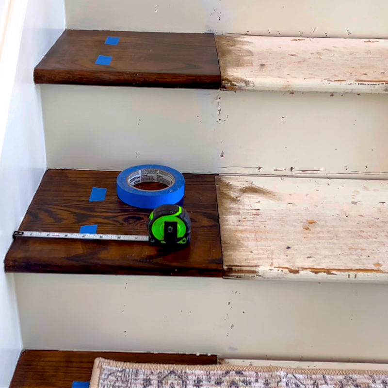 Painters tape and a tape measure on stairs.