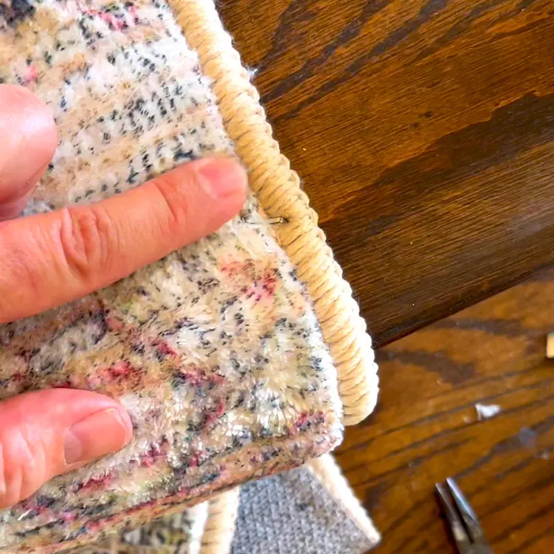 A staple on the rug border being installed on stairs.
