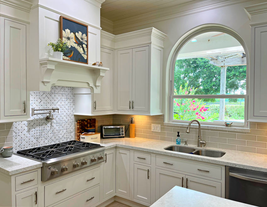 White kitchen cabinets and white walls in a large kitchen with high ceilings. Sherwin Williams Dover White.
