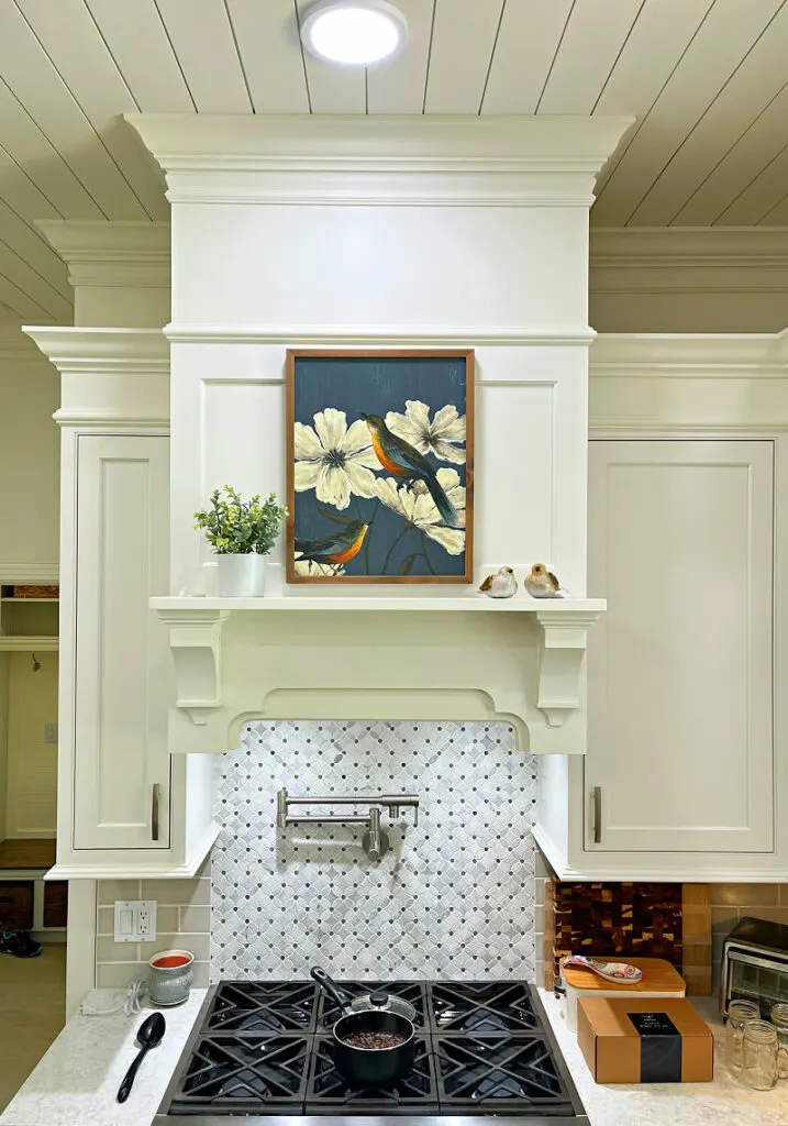 White Cabinet Range Hood to the ceiling with trim and a shelf.
