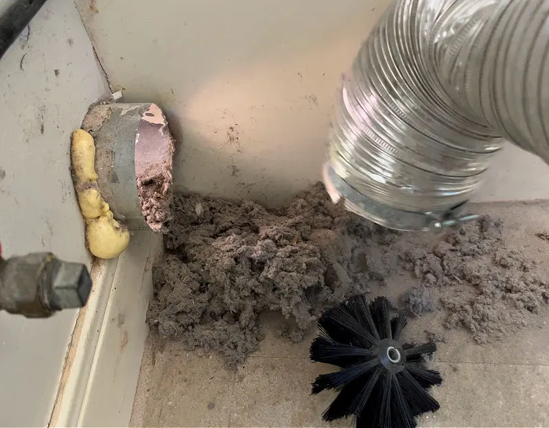 Pile of lint under a dryer vent pipe after it was disconnected.