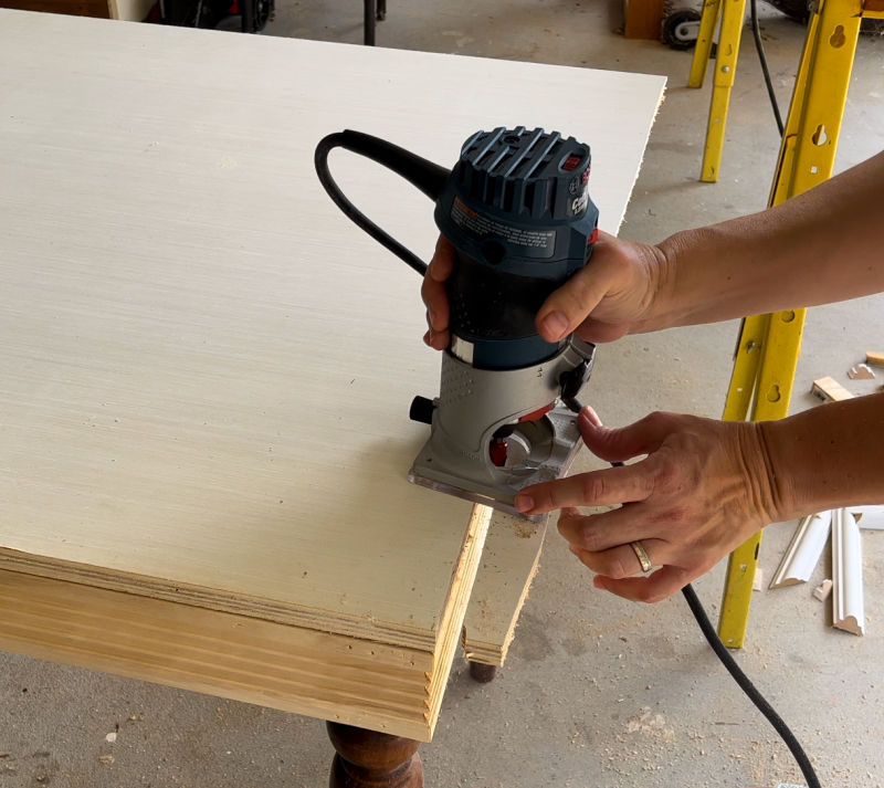 Cutting plywood flush with a handheld router.