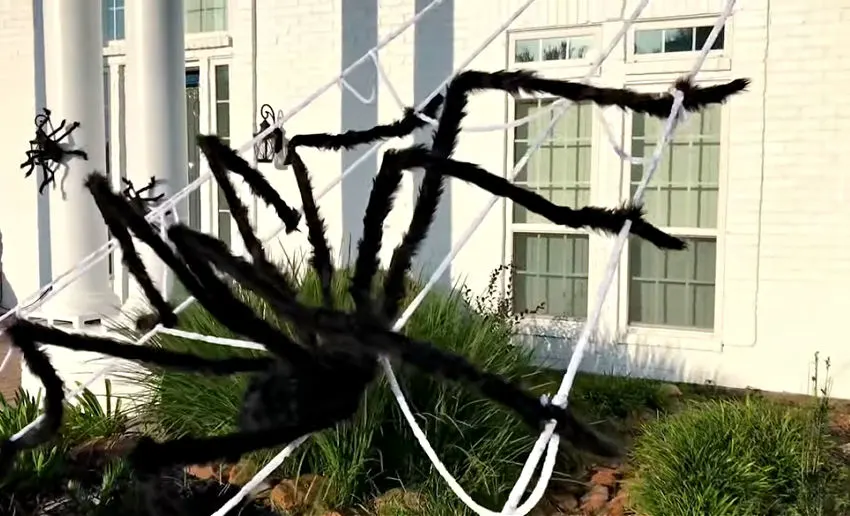Giant spider on a web outside on a brick house for Halloween.