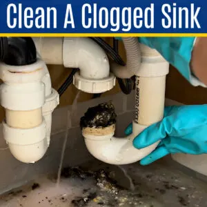 Image of a clogged kitchen sink p-trap for a post about the best ways to clean a clogged sink drain in a kitchen or bathroom.
