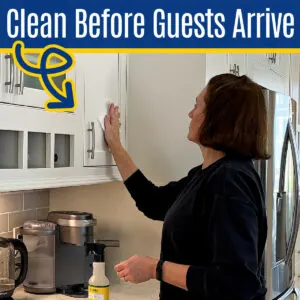 Image of someone cleaning kitchen cabinets for a post with 30 things to clean before guests arrive. Cleaning checklist.