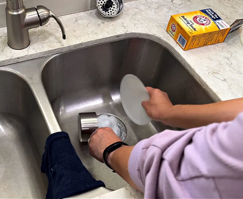 Using baking soda and vinegar to clear a clogged kitchen sink drain.