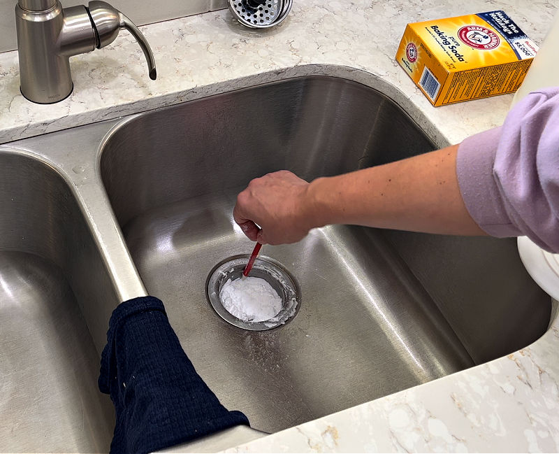 Using baking soda to clear a clogged kitchen sink drain.