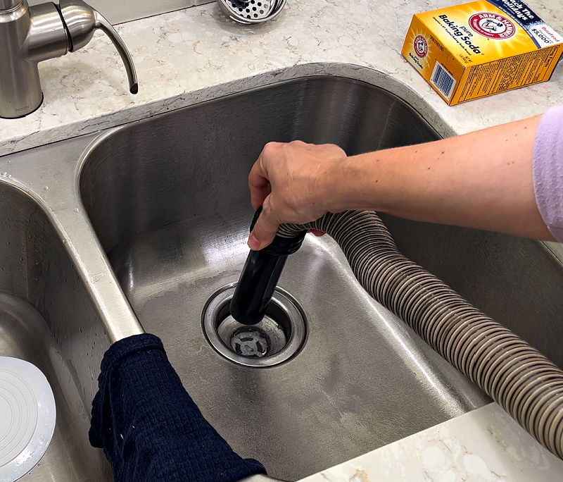 Using wet dry vac to clear a kitchen clogged sink drain.