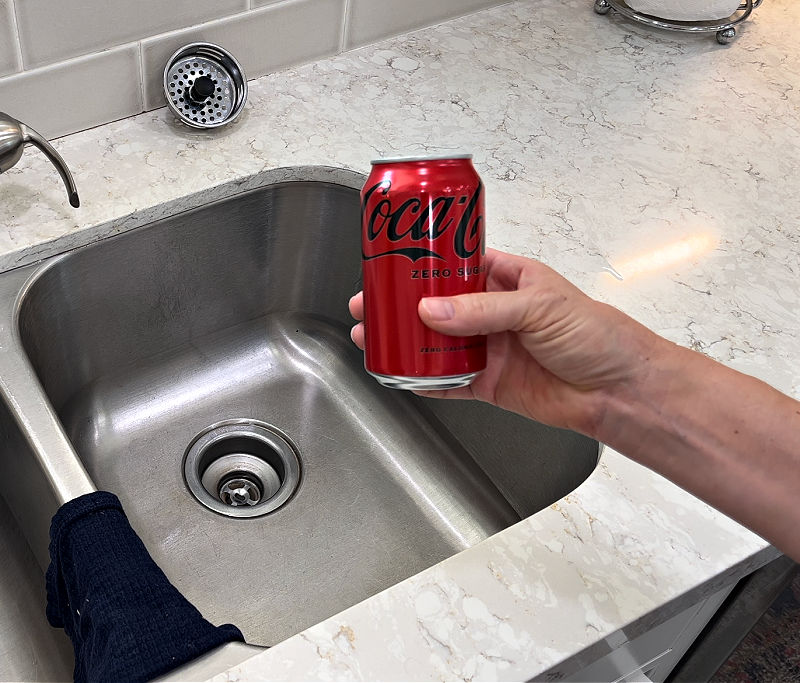 Using coca cola to clear a clogged kitchen sink drain.