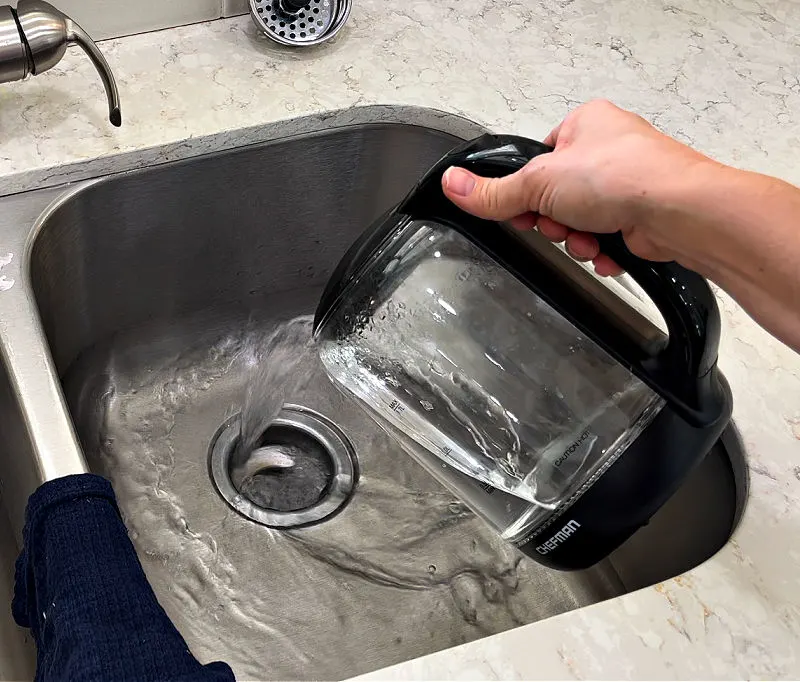 Using hot water to clear a clogged kitchen sink.