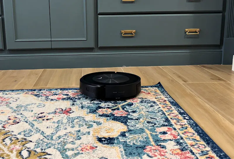 A Roomba on the floor, cleaning before guests arrive.