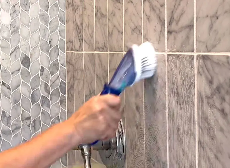 I like to clean grout in marble showers with Dawn Dish Soap and a mold and mildew removing spray.